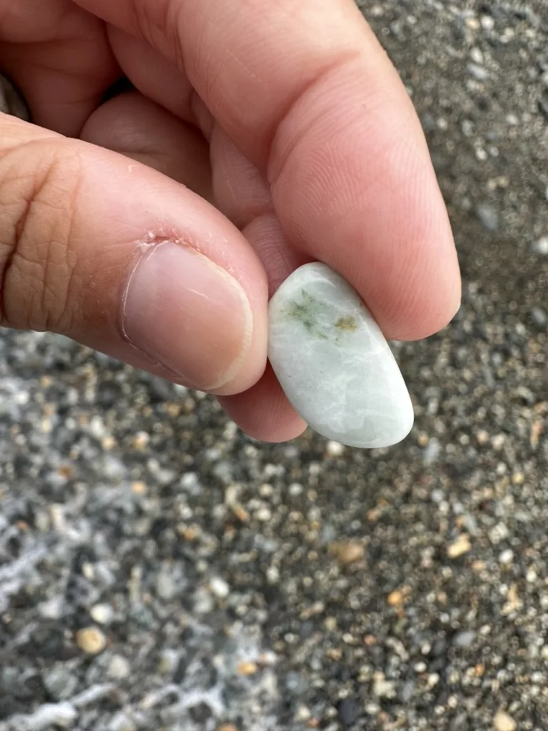 海岸で指先に持った白色地に淡緑色の模様があるヒスイ輝石岩と思われる礫